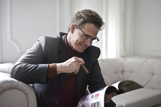 pexels-photo-3771100-3771100 Smiling rich gentleman wearing classy suit and stylish eyeglasses sitting with cigar on leather sofa in luxury living room and reading magazine